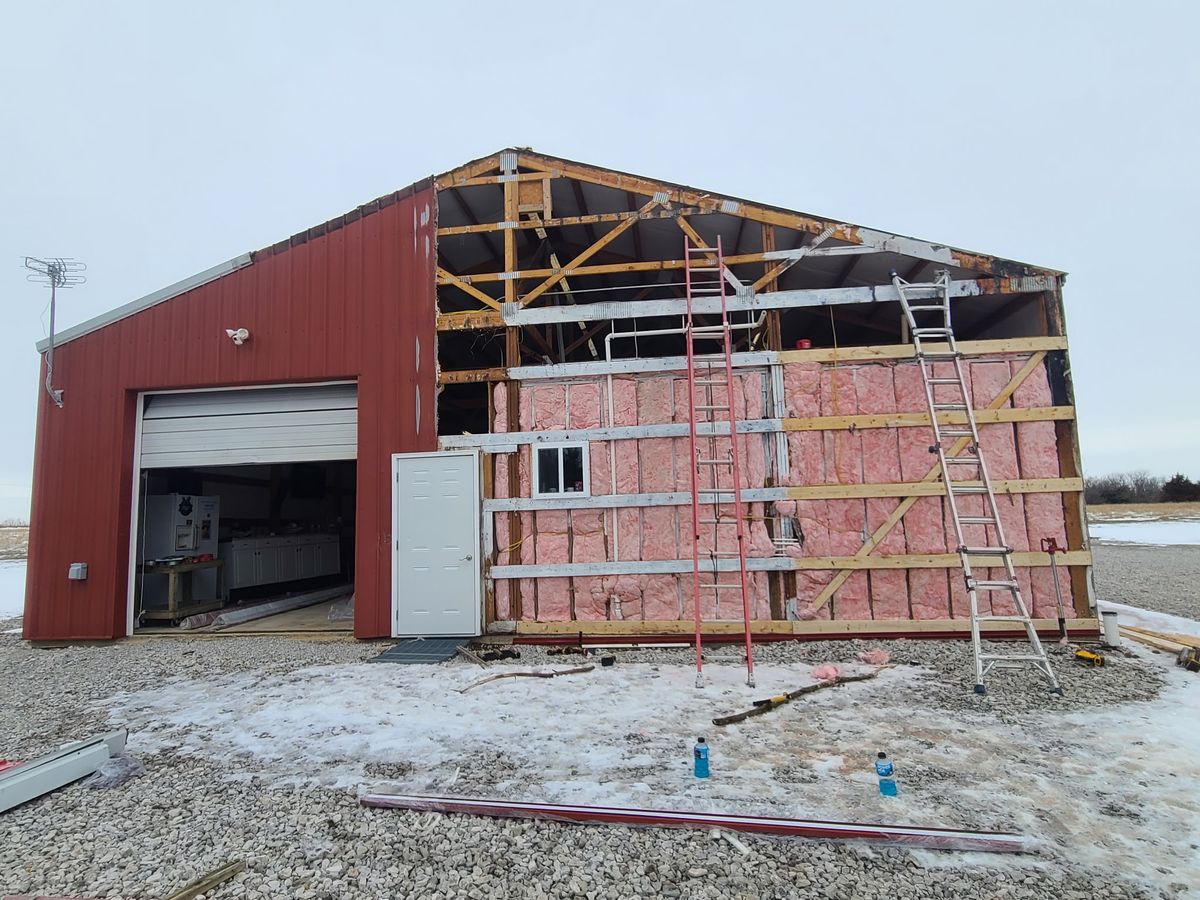 Metal building under construction with siding and insulation being installed