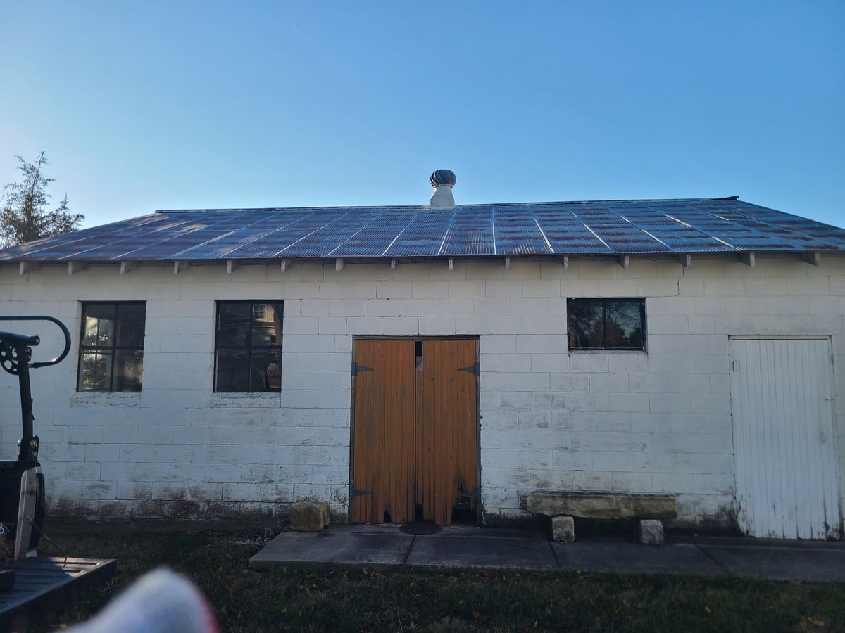Old worn roof on cinder block building before metal roof installation