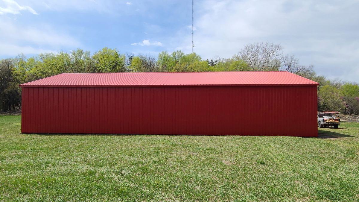 Large red metal pole barn side profile showing full length