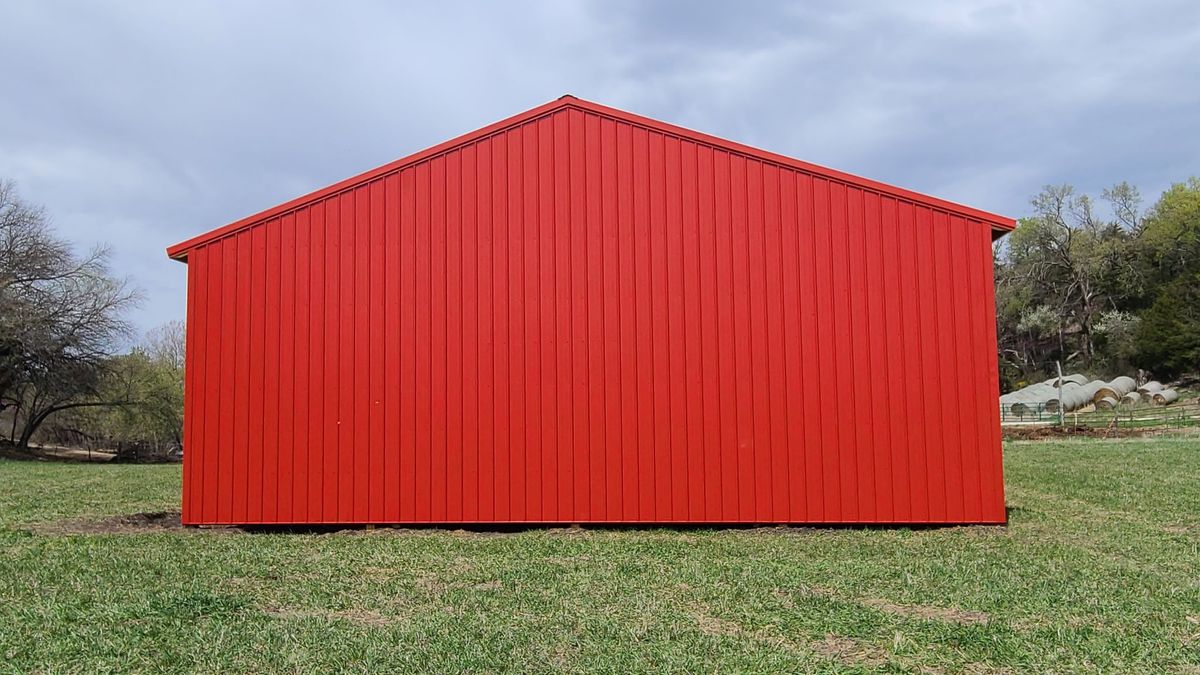Red metal building end view with clean siding finish
